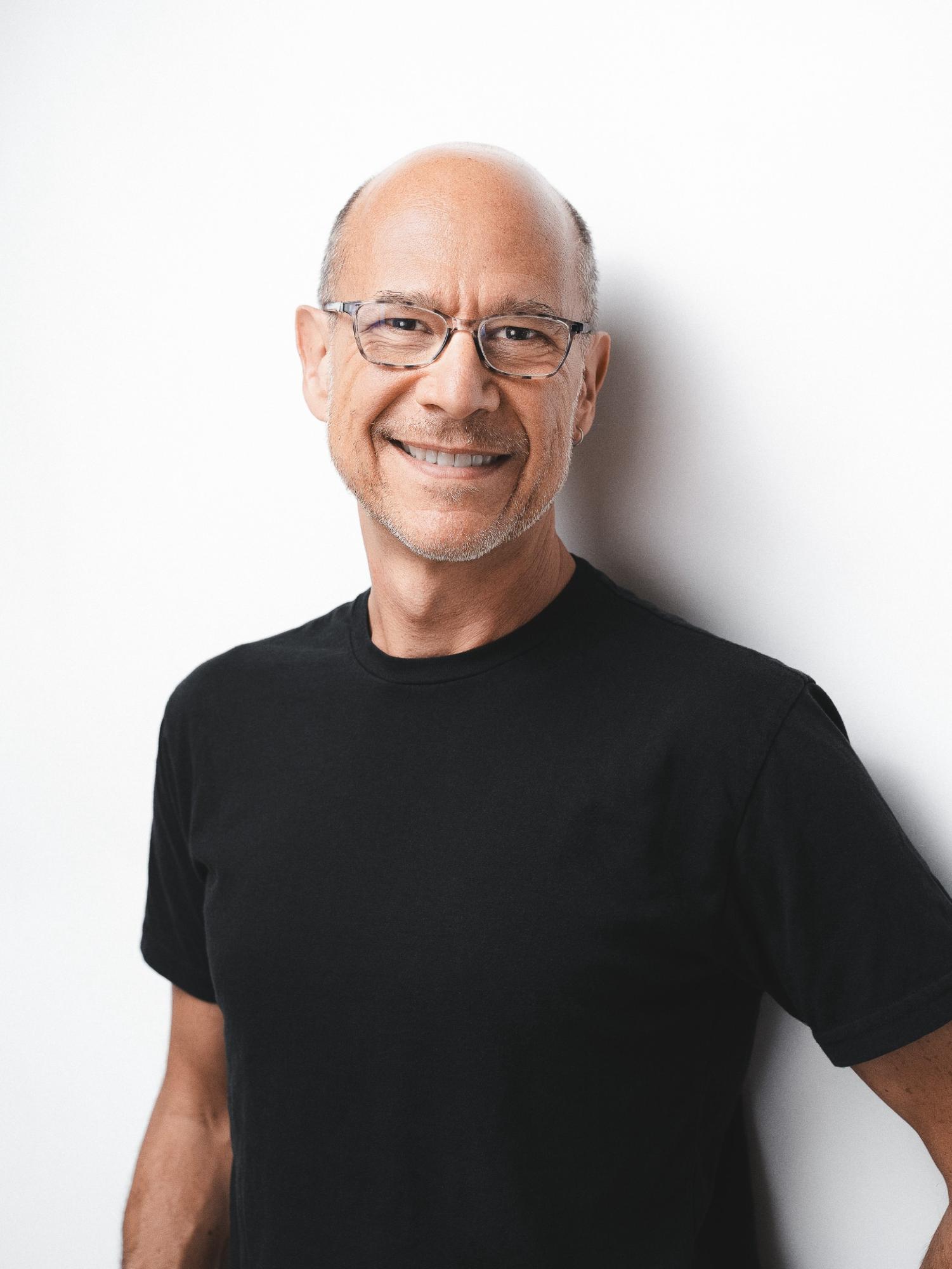 Corporate headshot photographed against a dark background