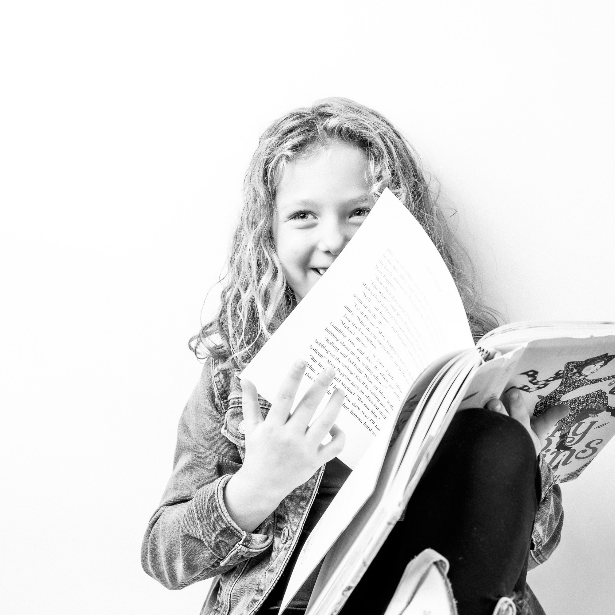 Studio portrait of a girl reading a book