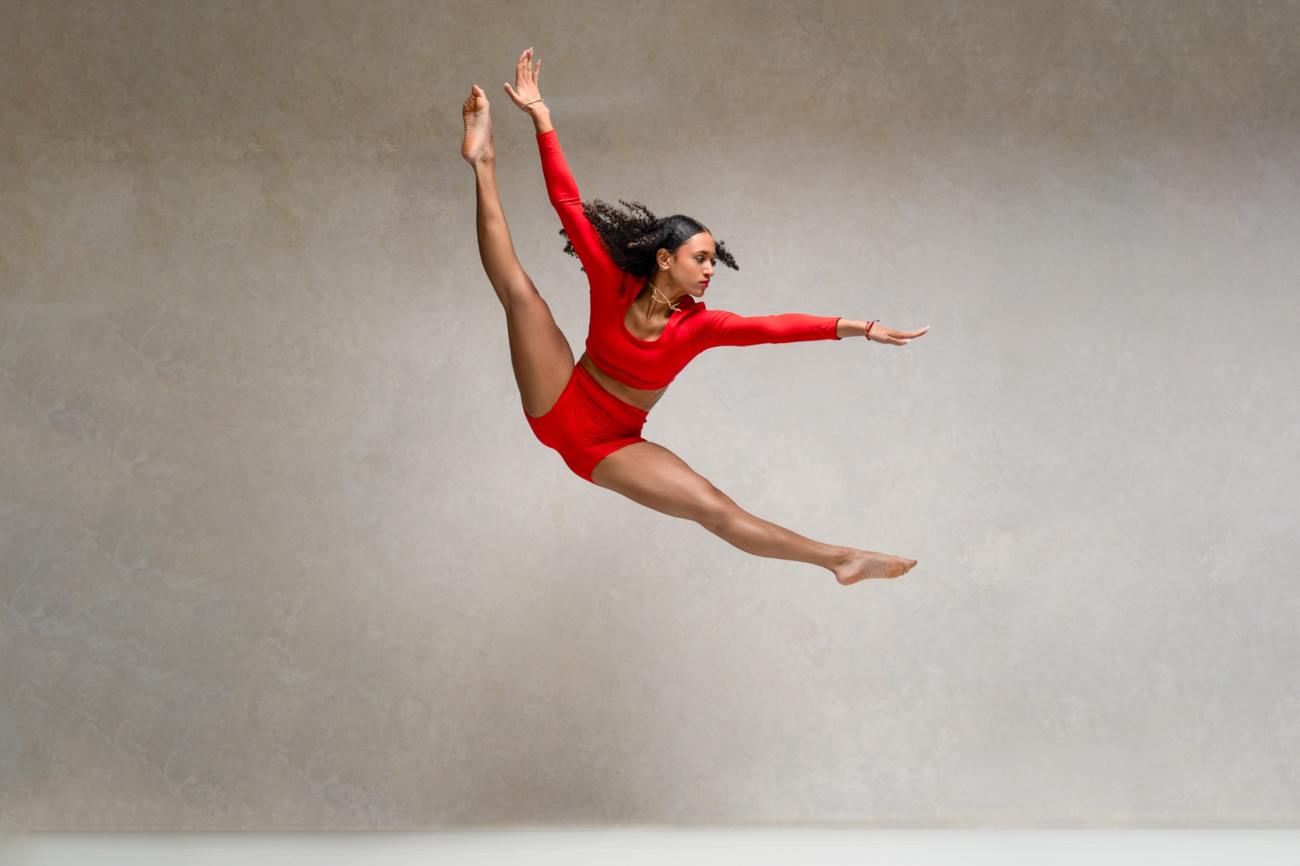 Dancer mid-leap in a red costume