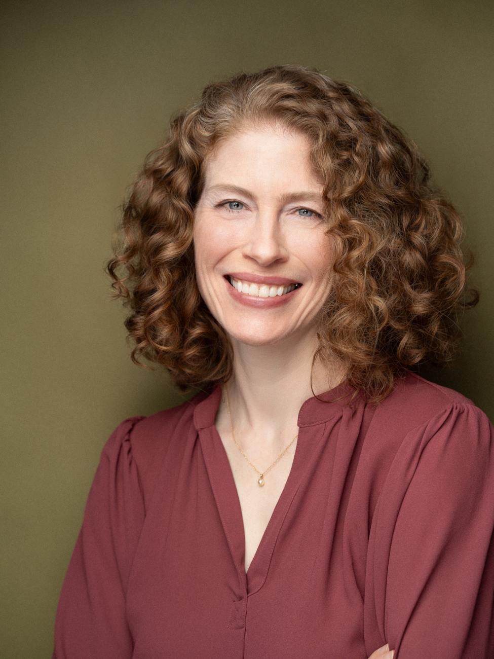 Professional headshot of a woman on a dark background